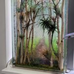 artistic plant composition inside glass panel